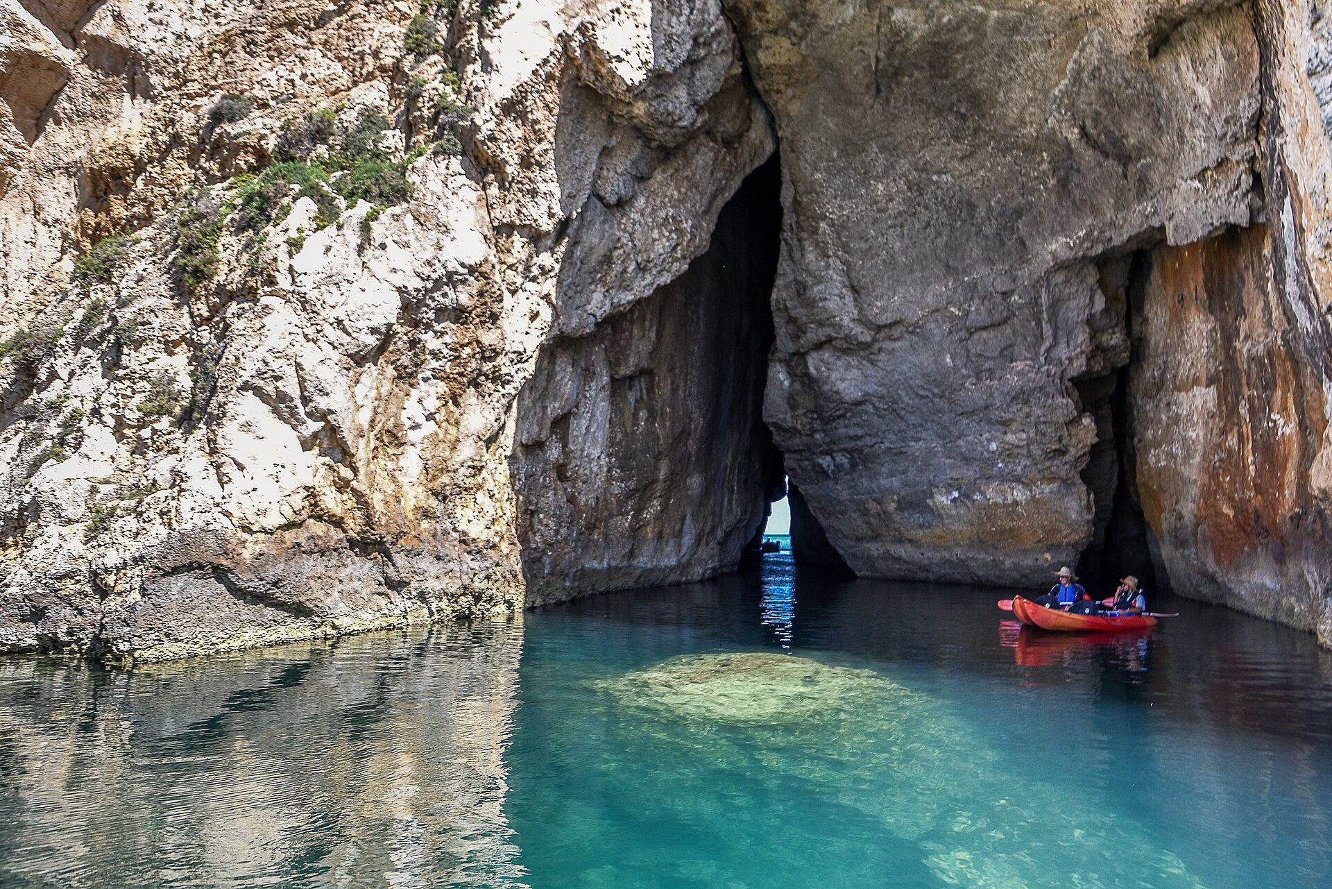 The tunnel connecting the Inland Sea at Dwejra to the open sea, with a small boat passing through it
