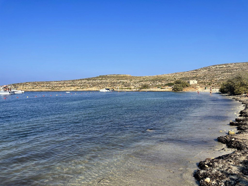 The sandy shallows of Santa Marija Bay on Comino's north coast, with the low headland behind